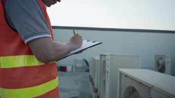 fabriek ingenieurs of personeel controle de koeling systeem van de fabriek. voor Mens records de staat van de compressor voordat onderhoud volgens onderhoud plan. video