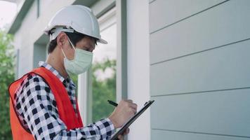 inspector o ingeniero está inspeccionando e inspeccionando un edificio o casa usando una lista de verificación. ingenieros y arquitectos o contratistas trabajan para construir la casa antes de entregársela al propietario. video