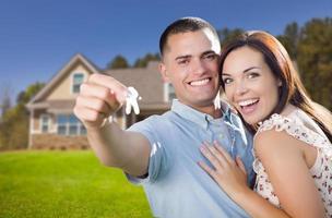 Military Couple with House Keys In Front of New Home photo