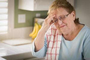 Sad Crying Senior Adult Woman At Kitchen Sink photo