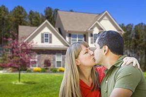 Mixed Race Couple Hugging in Front of House photo