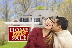 Couple in Front of Sold Real Estate Sign and House photo