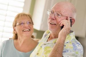 Senior Adult Husband on Cell Phone with Wife Behind photo