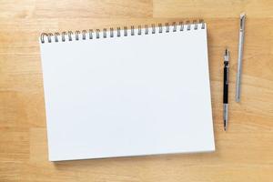 Carpeta de tabletas de papel de boceto en blanco que descansa sobre el escritorio con lápiz y regla de ingeniería foto