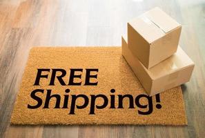 Free Shipping Welcome Mat On Wood Floor With Shipment of Boxes photo