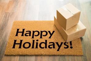 Happy Holidays Welcome Mat On Wood Floor With Shipment of Boxes photo