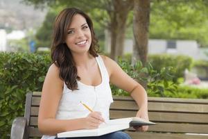 Young Adult Female Student on Bench Outdoors photo