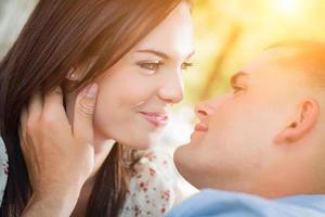 feliz retrato de pareja romántica de raza mixta en el parque. foto