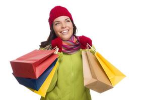 mujer de raza mixta con sombrero y guantes sosteniendo bolsas de compras foto