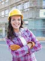 joven y atractiva trabajadora de la construcción con casco y guantes foto