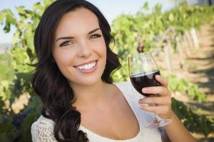 Young Adult Woman Enjoying A Glass of Wine in Vineyard photo