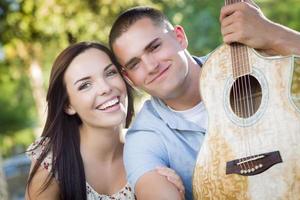 Mixed Race Couple Portrait with Guitar in Park photo