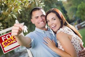 Military Couple with House Keys and Sold Real Estate Sign photo