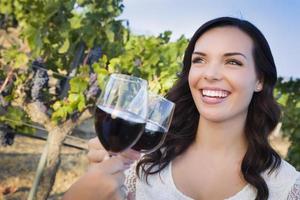 Young Woman Enjoying Glass of Wine in Vineyard With Friends photo