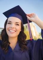 feliz graduarse mujer de raza mixta en toga y birrete foto