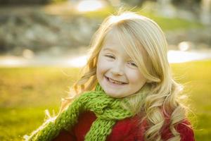 niña pequeña con abrigo de invierno y bufanda en el parque foto