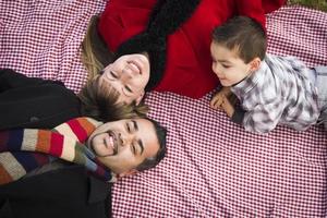 familia en ropa de invierno recostada sobre sus espaldas en el parque foto