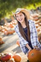 Preteen Girl Playing with a Wheelbarrow at the Pumpkin Patch photo
