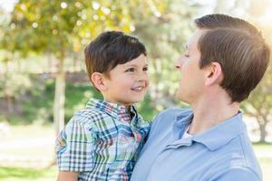 Happy Caucasian Father and Son Playing Together in the Park. photo