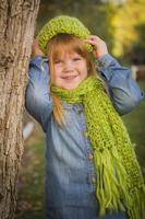 Portrait of Cute Young Girl Wearing Green Scarf and Hat photo