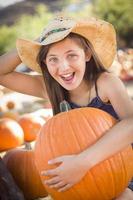 Preteen Girl Holding A Large Pumpkin at the Pumpkin Patch photo