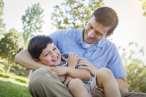 amoroso padre hijo cosquillas en el parque foto