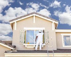 House Painter Painting the Trim And Shutters of Home photo