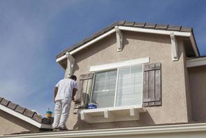 House Painter Painting the Trim And Shutters of Home photo