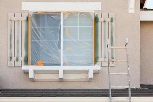 escalera de construcción apoyada contra una casa que se está pintando foto