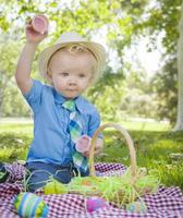 Cute Little Boy Enjoying His Easter Eggs Outside in Park photo