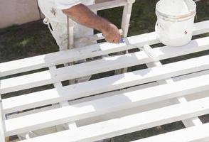 Painter Rolling White Paint Onto Top of Patio Cover photo