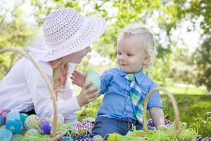 Cute Young Brother and Sister Enjoying Their Easter Eggs Outside photo