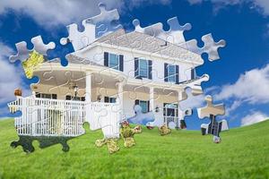 Puzzle Pieces Fitting Together Revealing Finished House Build Over Grass Field photo