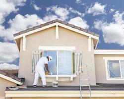 House Painter Painting the Trim And Shutters of Home photo