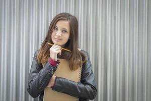 joven estudiante melancólica con libros mirando hacia un lado foto