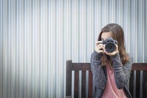 Girl Photographer Sitting and Pointing Camera photo