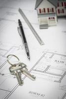 Home, Pencil, Ruler and Keys Resting On House Plans photo
