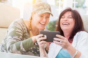 Two Female Friends Laugh While Using A Smart Phone photo