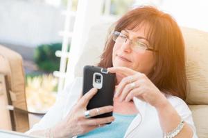 Attractive Middle Aged Woman Using Her Smart Phone photo