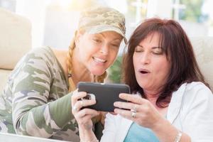 Two Female Friends Laugh While Using A Smart Phone photo