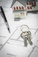 Model Home, Pencil and Keys Resting On House Plans photo
