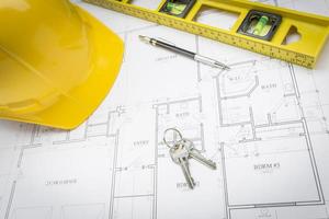 Hard Hat, Pencil, Level and Keys Resting on House Plans photo