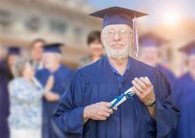 Proud Senior Adult Man In Cap and Gown At Outdoor Graduation Ceremony. photo