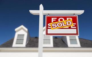 Right Facing Sold For Sale Real Estate Sign In Front of House and Deep Blue Sky. photo