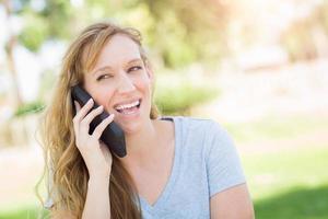 mujer adulta joven al aire libre hablando por su teléfono inteligente. foto