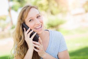 Young Adult Woman Outdoors Talking on Her Smart Phone. photo