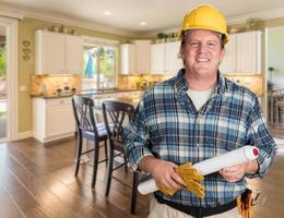 Contractor With Plans and Hard Hat Inside Custom Kitchen. photo