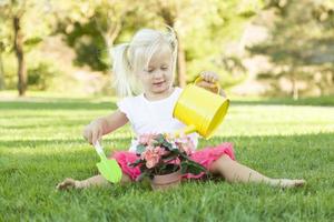 linda niña jugando al jardinero con sus herramientas y maceta. foto