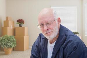 Senior Man in Empty Room with Packed Moving Boxes photo