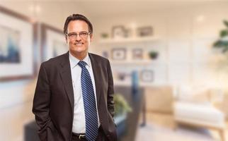 Handsome Businessman In Suit and Tie Standing in His Office photo